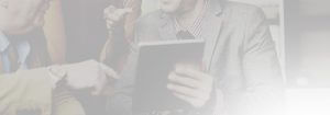 A man in a suit and tie holding an ipad.