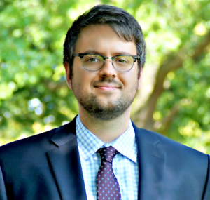 A man in a suit and tie standing outside.