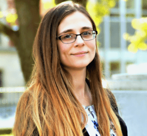 A woman with glasses is standing outside