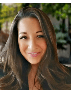 A woman with long hair smiling for the camera.