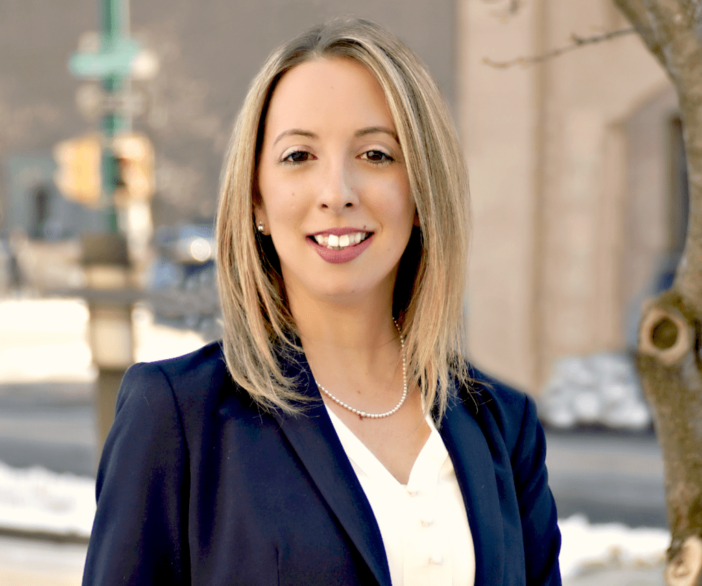 A woman in a suit standing on the street.