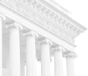 A white building with many pillars on top of it.