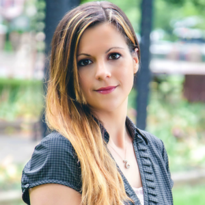 A woman with long hair is standing outside.