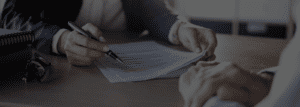 A person is writing on paper with a pen.