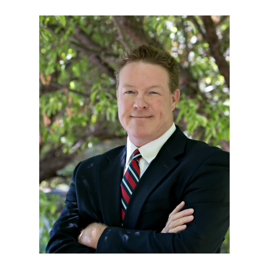 A man in suit and tie with his arms crossed.