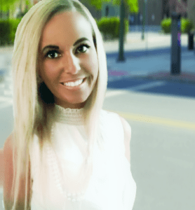 A woman with long blonde hair smiling for the camera.