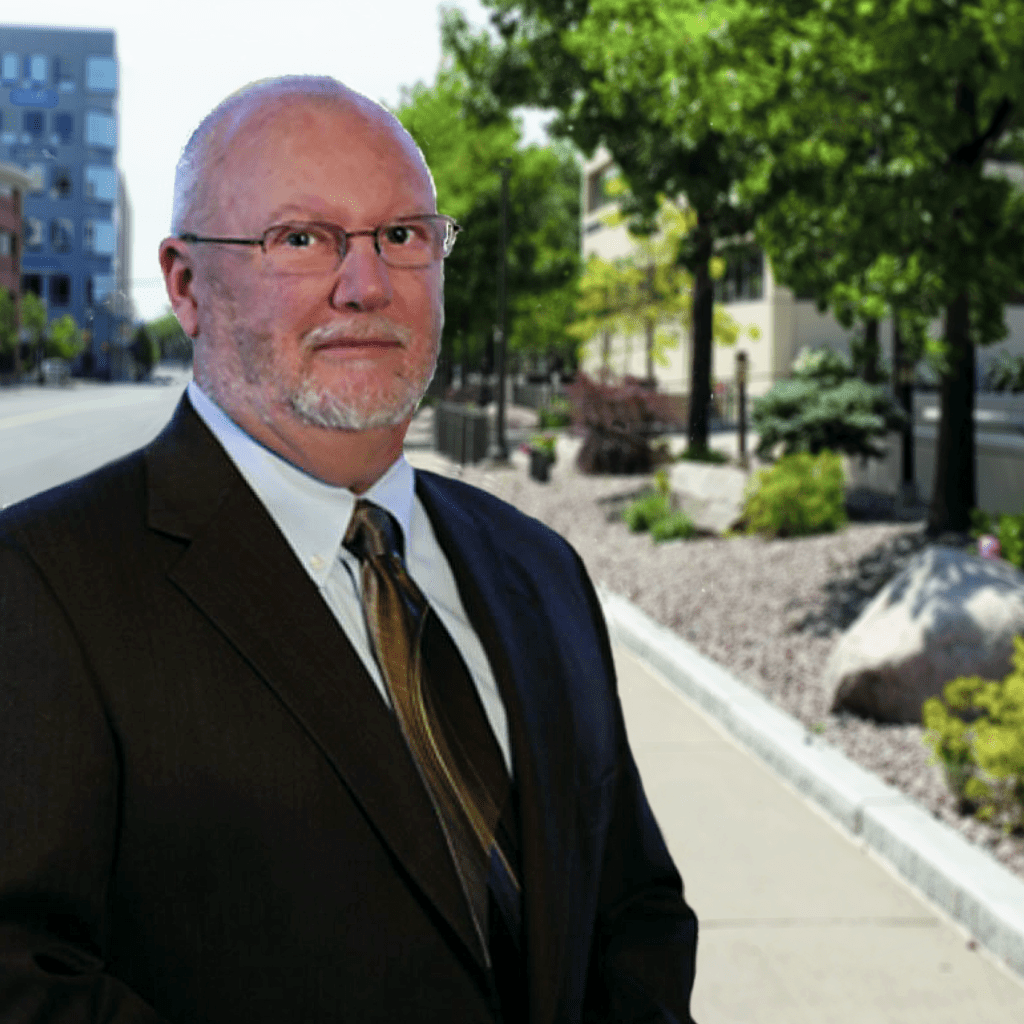 A man in a suit and tie standing on the side of a road.