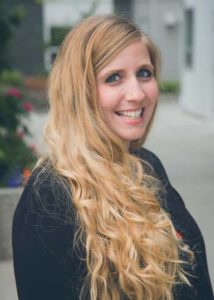 A woman with long blonde hair smiling for the camera.