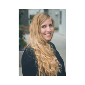 A woman with long blonde hair standing outside.