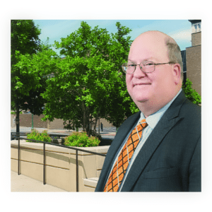 A man in suit and tie standing outside.