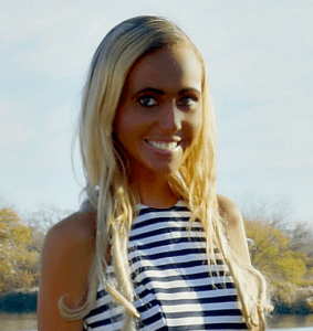 A woman with long blonde hair wearing a striped shirt.