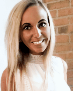 A woman with long blonde hair wearing white.