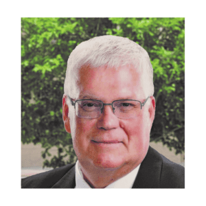 A man with white hair and glasses wearing a suit.