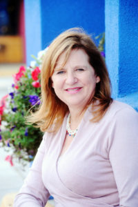 A woman with red hair and wearing pink shirt.