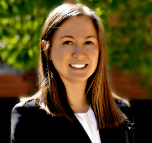 A woman in black jacket smiling for the camera.