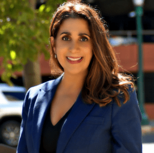 A woman in a blue suit standing on the street.
