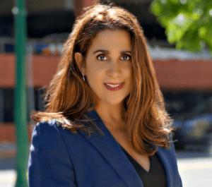A woman in a blue jacket standing outside.