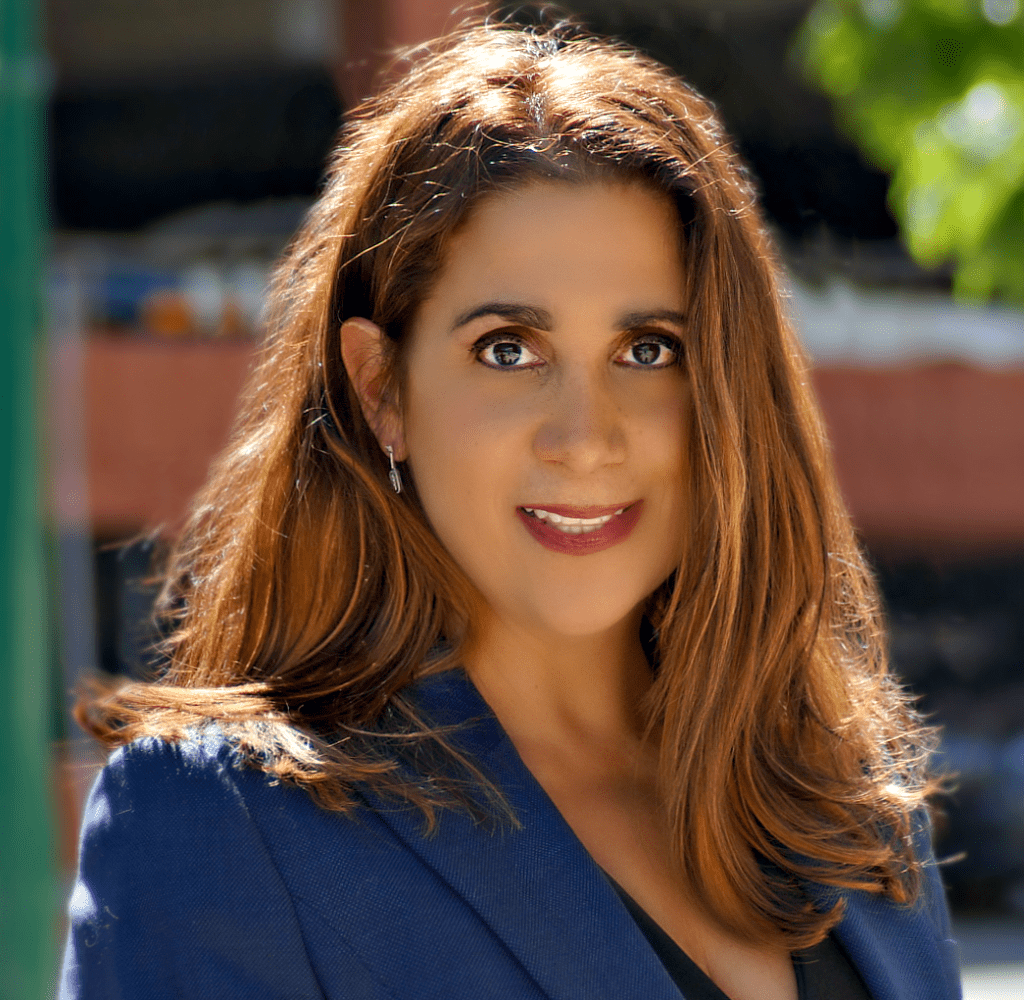 A woman with long hair wearing a blue jacket.