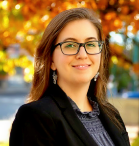 A woman wearing glasses and a black jacket.