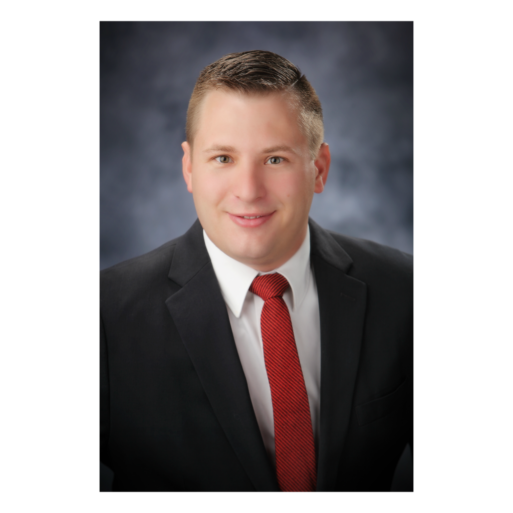 A man in a suit and tie standing up against a wall.