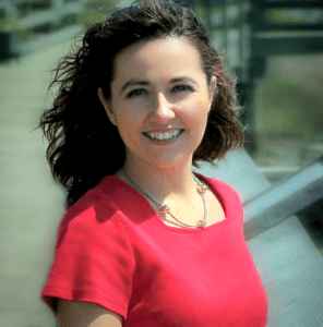 A woman in red shirt smiling for the camera.