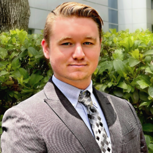 A man in a suit and tie standing outside.