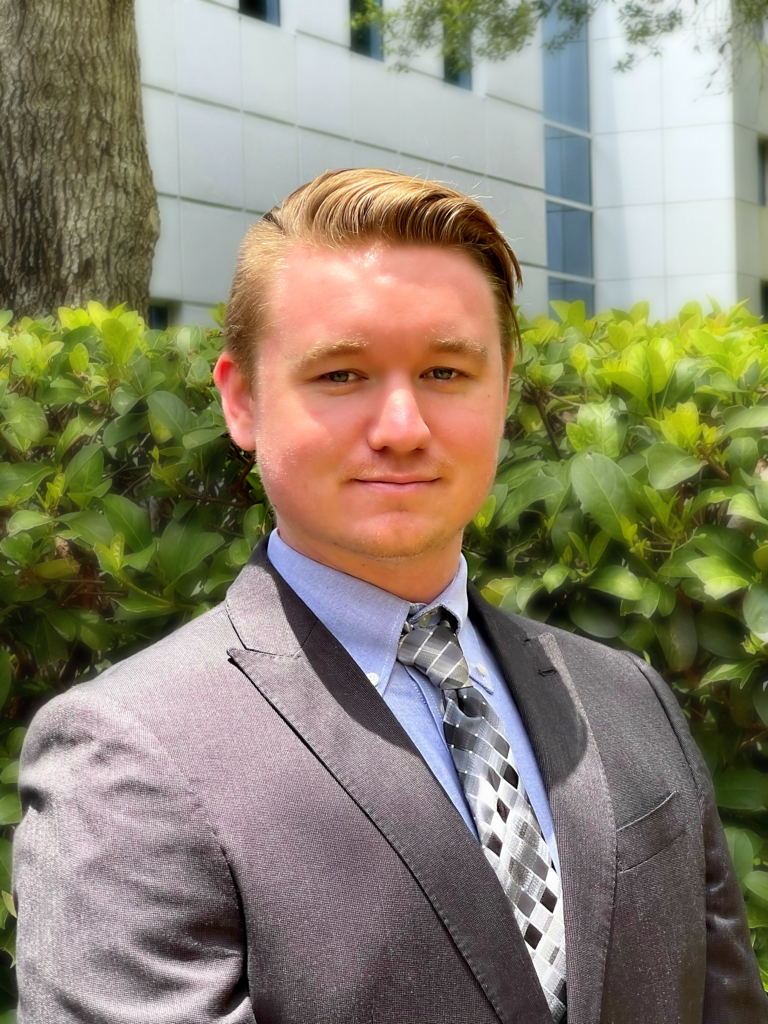 A man in a suit and tie standing outside.