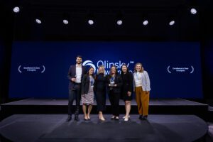 Group posing on stage with awards.